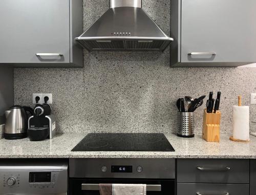 een keuken met een spoelbak en een fornuis bij Apartamento acogedor y familiar - WiFi+Chromecast in Puigcerdà