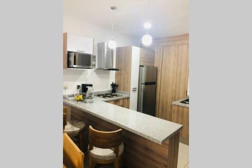 a kitchen with wooden cabinets and a counter top at Modern Decor Apartment near ocean in Mazatlán