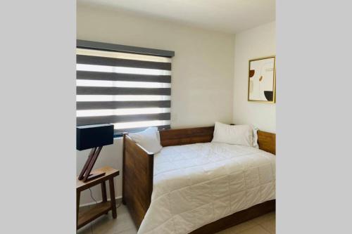 1 dormitorio con cama y ventana en Modern Decor Apartment near ocean en Mazatlán