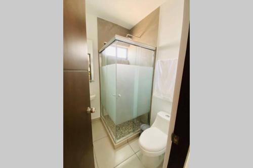 uma casa de banho com um WC e uma cabina de duche em vidro. em Modern Decor Apartment near ocean em Mazatlán