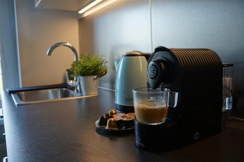 a coffee maker sitting on a kitchen counter with a drink at Apartament Gliwice Centrum Fredry I in Gliwice