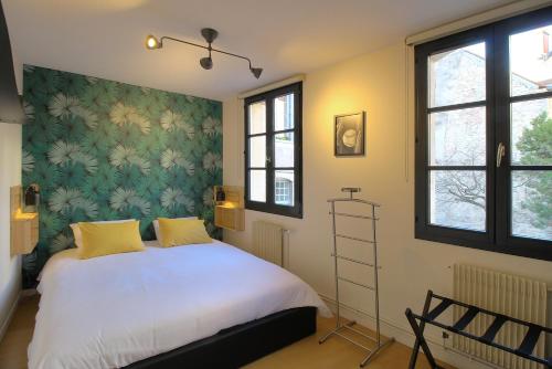 une chambre avec un lit blanc avec des oreillers jaunes dans l'établissement La Terrasse, à Dijon