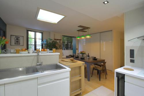 a large kitchen with a sink and a table at La Terrasse in Dijon