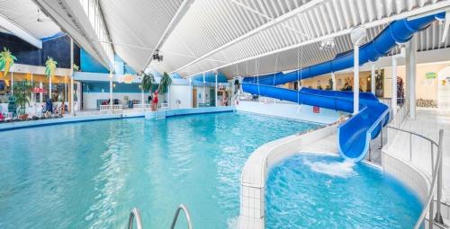 a large swimming pool with a blue water slide at Ostreahof Gezin & Familie vakantiehuis aan strand en jachthaven in Kamperland