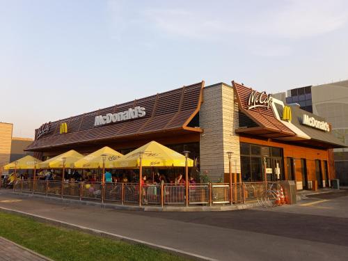 a restaurant with yellow umbrellas in front of a building at "Ботанический сад" Тихий район Квартира in Almaty