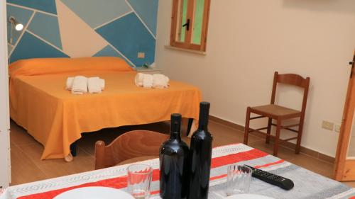 a room with a table with two bottles of wine at Villaggio Elisena in Vieste