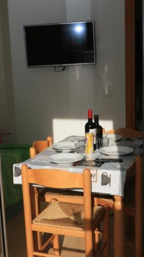 a dining room table with plates and wine bottles on it at Villaggio Elisena in Vieste