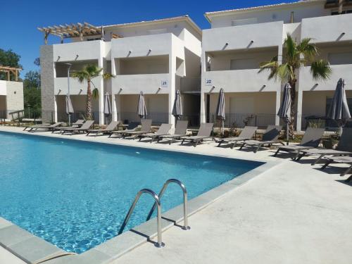 une piscine devant un hôtel dans l'établissement MARINE DE BRAVONE T2 Terrasse Front de mer - Plage pieds dans l'eau - Clim - Piscine - WIFI, à Linguizzetta