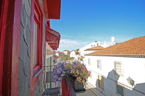 a building with a window with flowers in a window box at Casa do Tablado - Foz Côa in Vila Nova de Foz Coa