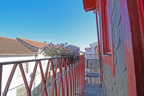 a balcony with a red railing and a chair on it at Casa do Tablado - Foz Côa in Vila Nova de Foz Coa