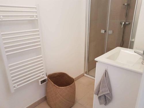 une salle de bain blanche avec un lavabo et une douche dans l'établissement MARINE DE BRAVONE T2 Terrasse Front de mer - Plage pieds dans l'eau - Clim - Piscine - WIFI, à Linguizzetta