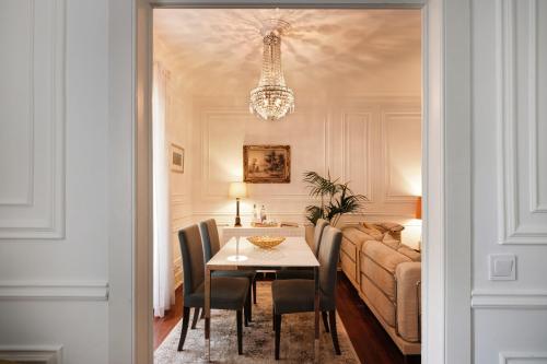 a dining room with a table and chairs and a bed at Casa da Fonte - Holiday Apartments in Cascais