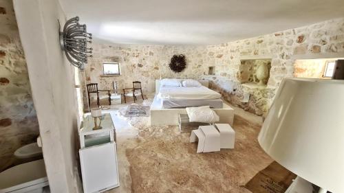 una camera con due letti in una stanza con pareti in pietra di Pietrefitte a Ostuni