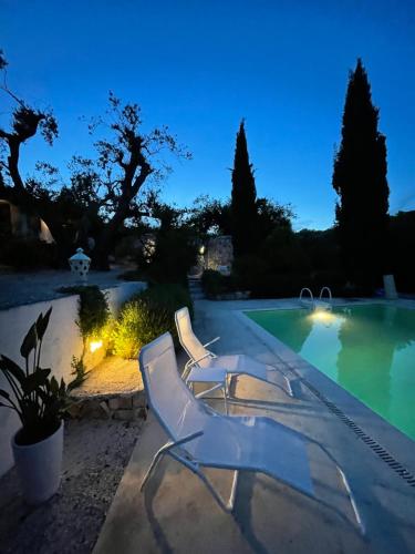 a swimming pool with two lounge chairs next to a swimming pool at Pietrefitte in Ostuni