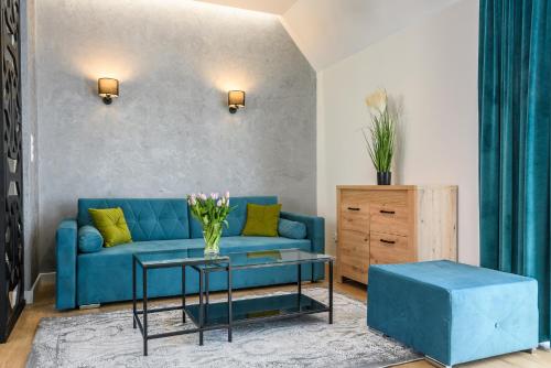 a living room with a blue couch and a table at Pokoje, Noclegi, Apartamenty Dune Resort Łeba in Łeba