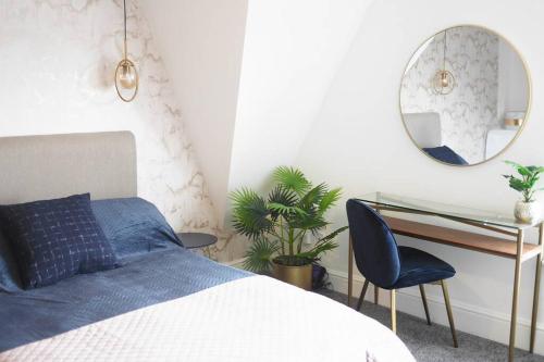 a bedroom with a bed and a desk and a mirror at Paradise St Apartment Top Floor 3 flights of stairs 3 bed 1 bathroom in Rhyl