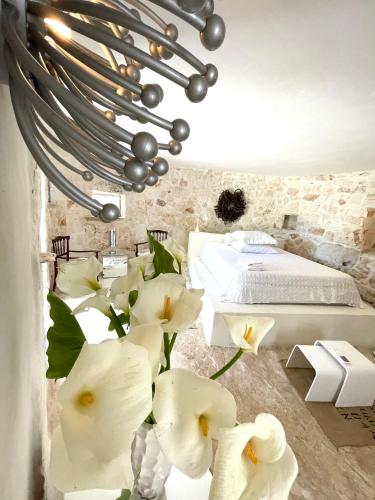 a bedroom with a bed and white flowers at Pietrefitte in Ostuni