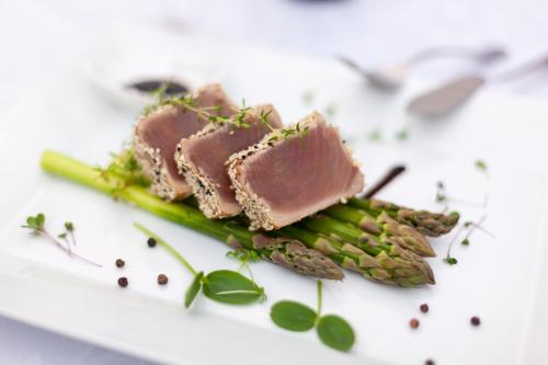 a plate of food with meat and asparagus at Boutique Hotel Budzak in Ždiar