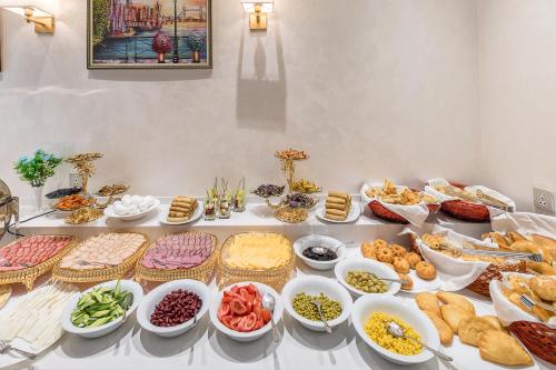 タシュケントにあるQushbegi Plaza Hotelのさまざまな種類の食べ物が並んだテーブル