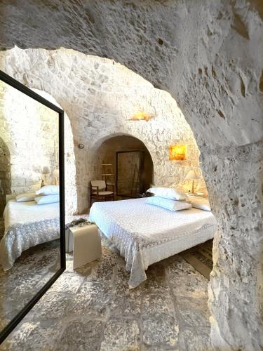 a bedroom with two beds in a stone wall at Pietrefitte in Ostuni