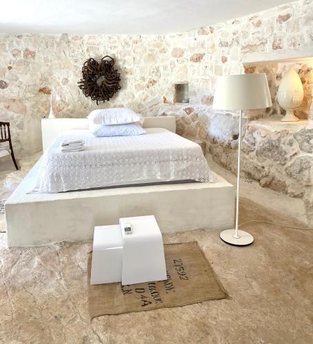 a bedroom with a bed with a lamp and a rug at Pietrefitte in Ostuni