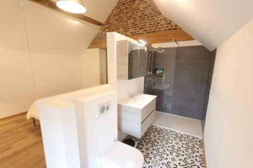 uma casa de banho branca com um lavatório e um chuveiro em Loft à la campagne/ 1ère occupation em Visé