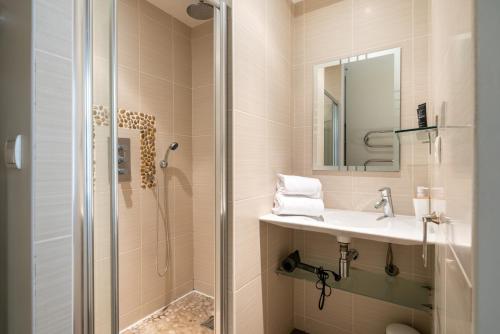 a bathroom with a shower and a sink and a mirror at Honorê, Suite Saint Georges in Lyon