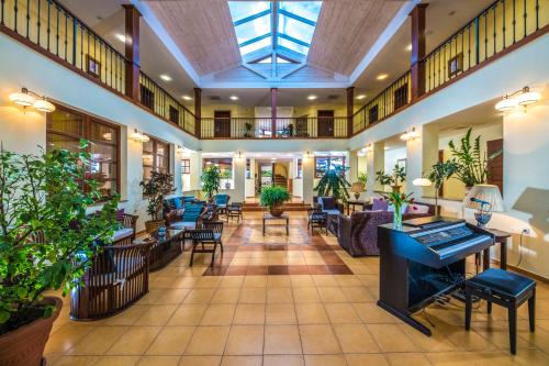 a lobby of a hotel with tables and chairs at Bakony Resort - a Felnőttbarát Hotel - Szarvaskút Vendégpark in Zirc