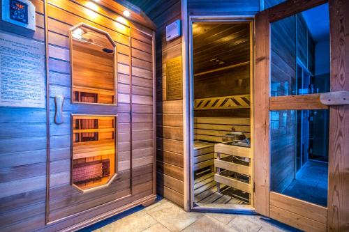 a sauna with wooden walls and a glass door at Bakony Resort - a Felnőttbarát Hotel - Szarvaskút Vendégpark in Zirc