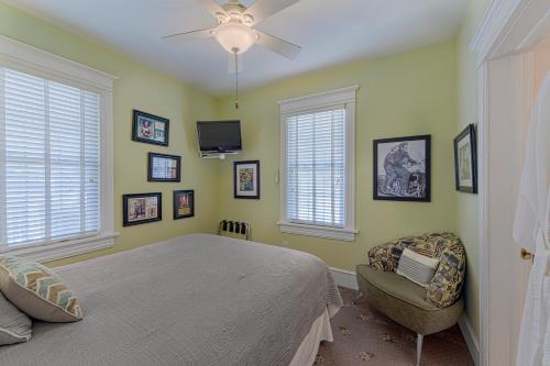 a bedroom with a bed and a chair and windows at Summer Nites in North Wildwood
