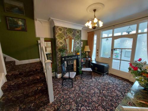 een woonkamer met een trap en een open haard bij The Hilary Guesthouse in Llandudno
