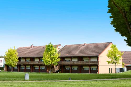 a large building with trees in front of it at Campanile NATURE - Besançon Ouest Chateaufarine in Besançon