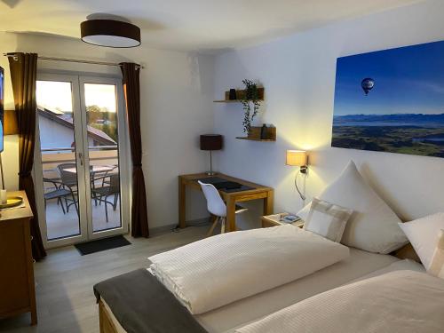 a bedroom with a bed and a balcony with a table at Haus Langweid - Moderne Ferienwohnungen mit Luxus im Inntal in Neubeuern