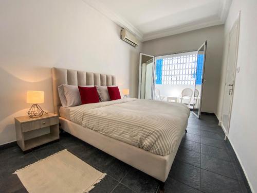 um quarto com uma cama grande e almofadas vermelhas em Cosy Duplex in Sidi Bou Said em Dar Mimoun Bey