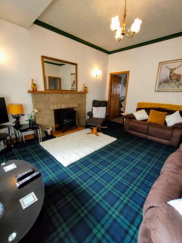 a living room with a couch and a fireplace at The Old Smiddy Cottage and Apartment in Balloch