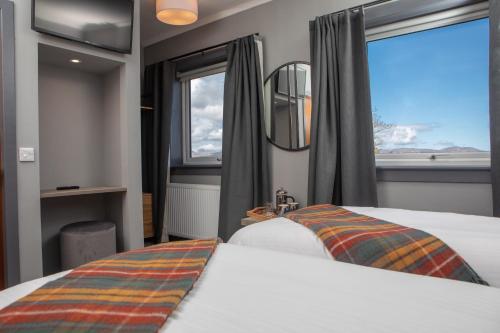 una camera d'albergo con due letti e una finestra di Hebridean Inn a Broadford