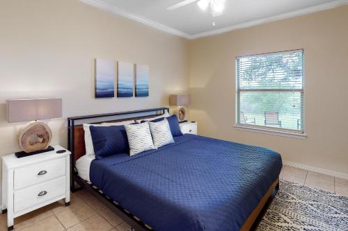 - une chambre avec un lit bleu et une fenêtre dans l'établissement Horseshoe Bay Haven, à Horseshoe Bay