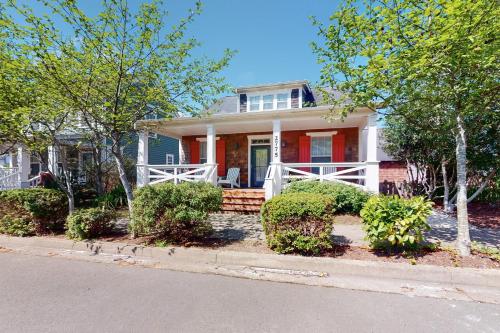 a home with a red and white house with trees at Looney Dunes in Lincoln City