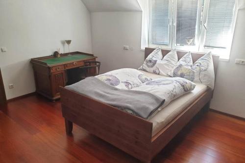 a bed in a room with a table and a window at Alte Villa 400m2 Seegrund nur für euch - old villa with 400m2 beach just for you in Maria Wörth