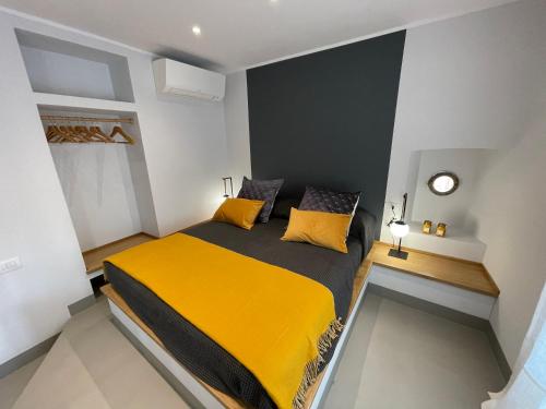 una camera da letto con un grande letto con cuscini gialli di Mare e Cielo Luxury Apartment (1BR) a Sestri Levante