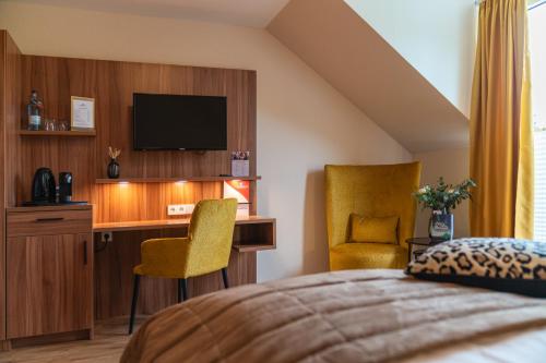 a bedroom with a bed and a desk with a television at Parkhotel in Bad Waldsee
