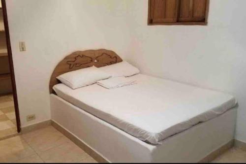 Ce petit lit se trouve dans un dortoir doté d'un matelas blanc. dans l'établissement PLAYA BLANCA SANANTERO CORDOBA las palmeras D’JC, à San Antero