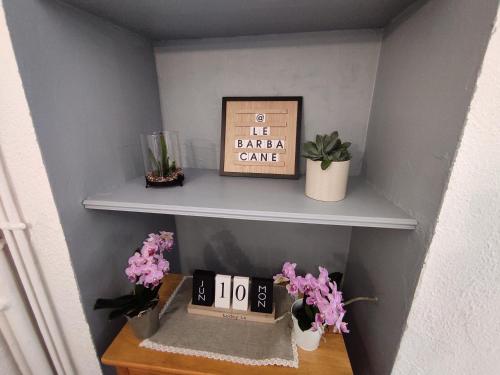 une étagère avec une horloge et des fleurs sur elle dans l'établissement barbacane, à Carcassonne