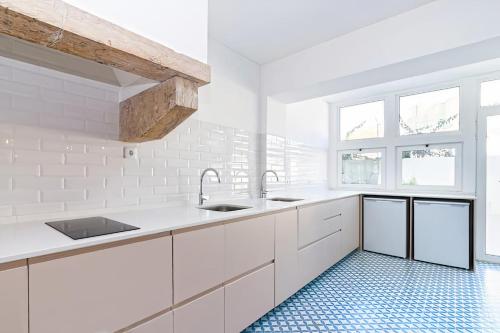 a kitchen with white cabinets and a blue tile floor at The Albuquerque Suites Self Check in in Lisbon