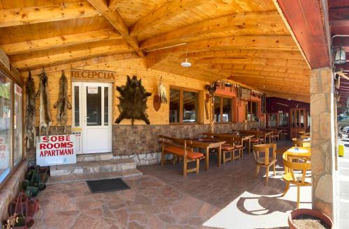 a restaurant with wooden ceilings and tables and chairs at Hotel Lovac in Žabljak