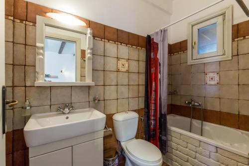 Un baño con inodoro, lavabo y bañera. en Villa Glysteri, en Skopelos Town