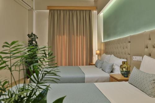 una habitación de hotel con 2 camas y una planta en Irida Apartments, en Leptokarya