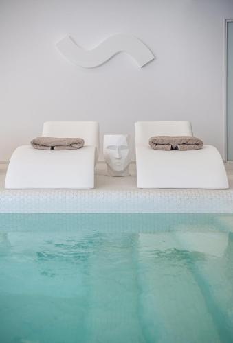 two beds with towels on them next to a swimming pool at Lagon Life Spirit Boutique Hotel - Adults Only in Chania Town