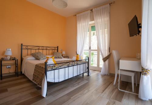 a bedroom with a bed and a desk and a window at B&B Sogno - Camere con vista a Vietri Sul Mare in Vietri