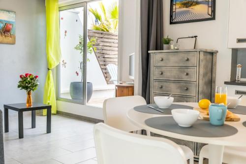 une salle à manger avec une table et des chaises et une fenêtre dans l'établissement LE FARNIENTE - BELLE TERRASSE Wifi Parking à 5 Min des PLAGES - TOP PROS SERVICESConciergerie La Grande Motte, à La Grande Motte